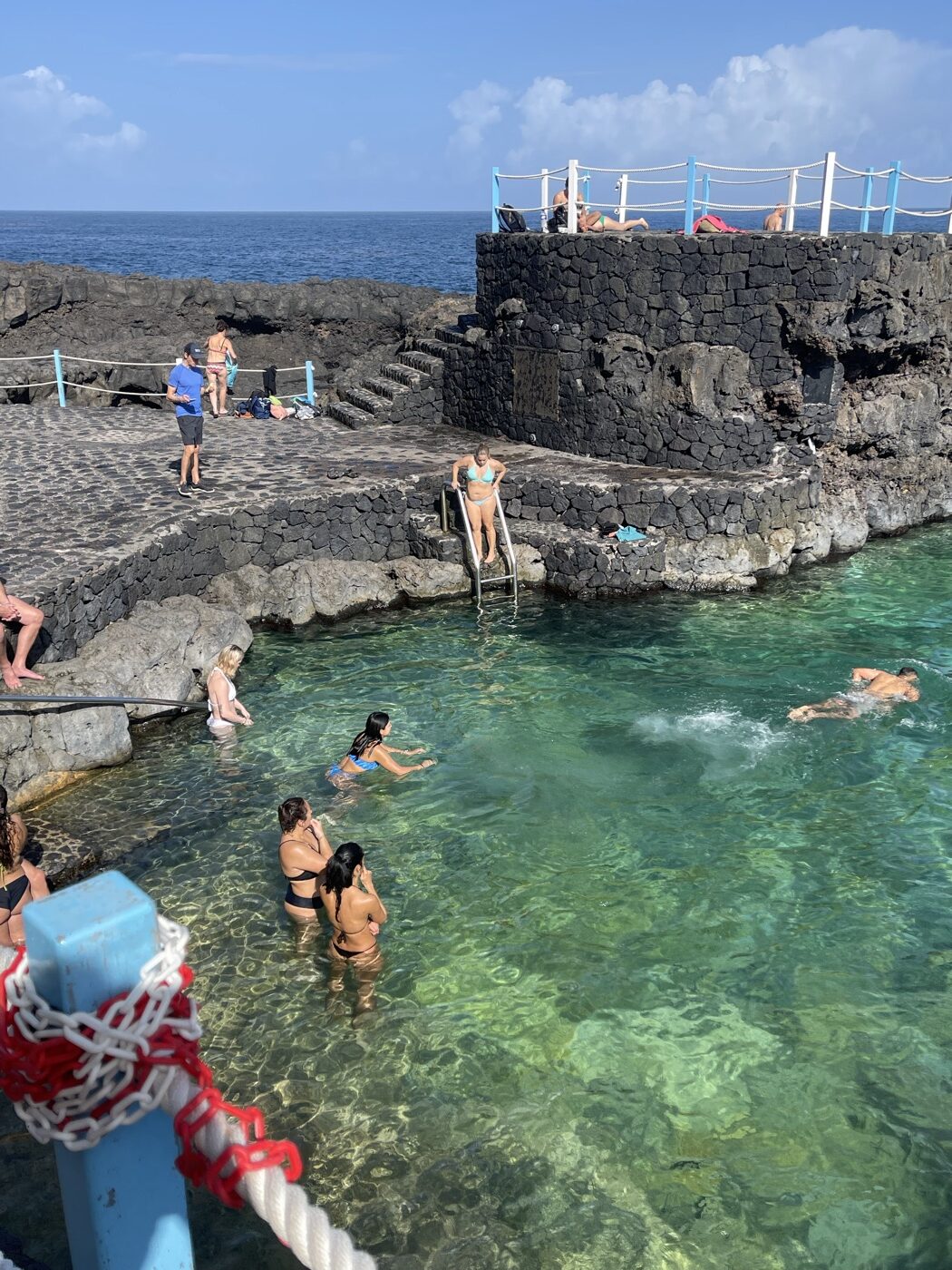 Badegäste im türkisen Meerwasser-Naturschwimmbecken von Charco Azul
