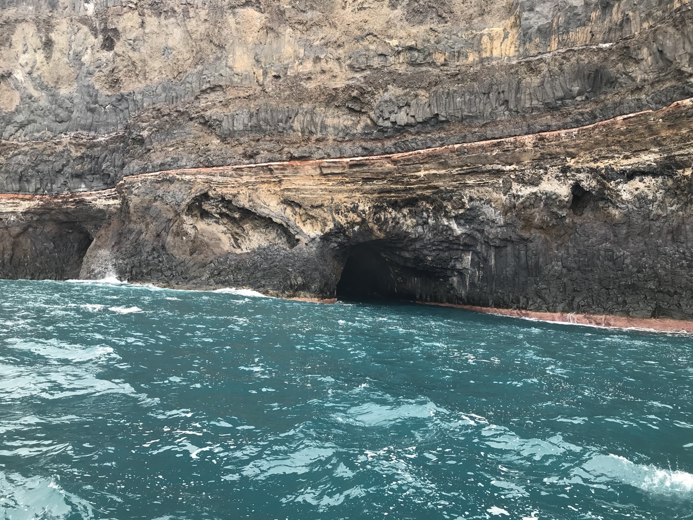 Vulkan-Steilküste mit Meereshöhlen und türkisem Wasser bei Tijarafe, La Palma, vom Boot